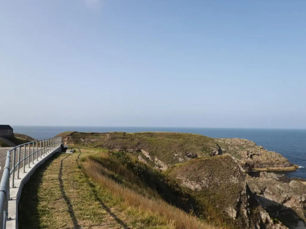 a road on a cliff next to the ocean at 18b New Street in Buckie