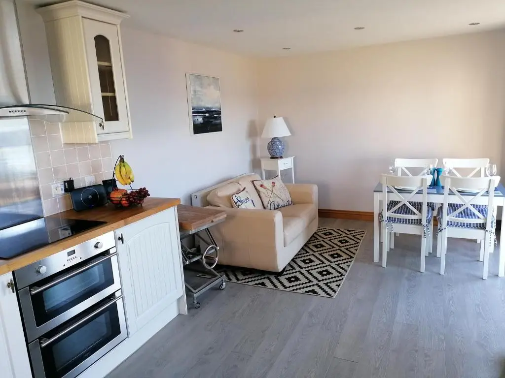 a kitchen and living room with a couch and a table at Sunnyside House in Gardenstown