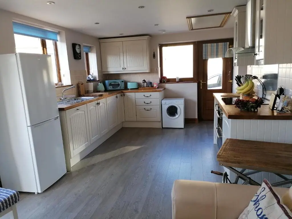 a kitchen with a white refrigerator and a table at Sunnyside House in Gardenstown