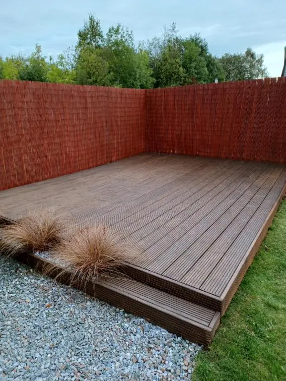 a wooden deck in front of a brick fence at Modern 2 Bedroom Semi detached House with own private driveway in Inverness