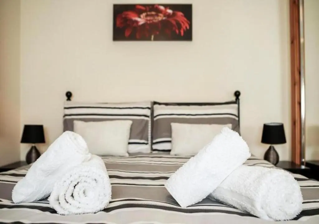 a bedroom with a bed with towels on it at Modern 2 Bedroom Semi detached House with own private driveway in Inverness