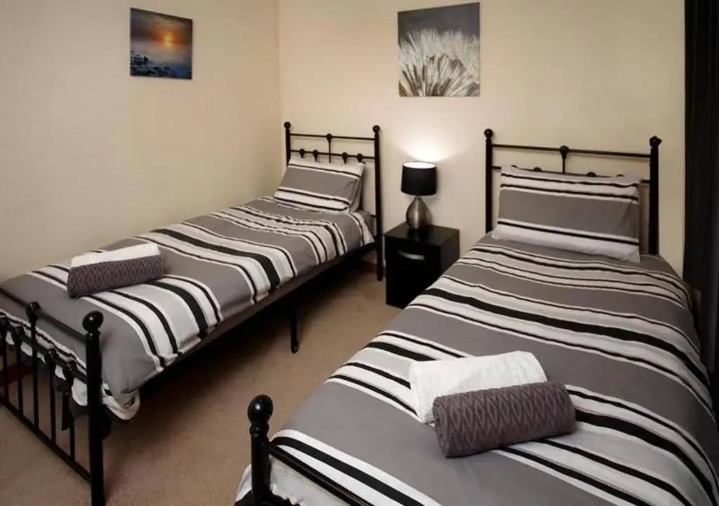two twin beds in a room with at Modern 2 Bedroom Semi detached House with own private driveway in Inverness