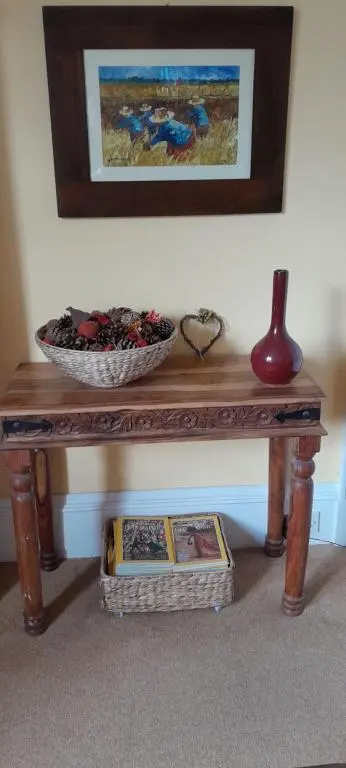 a wooden table with a bowl and a basket on top at Strome Lodge in Inverness
