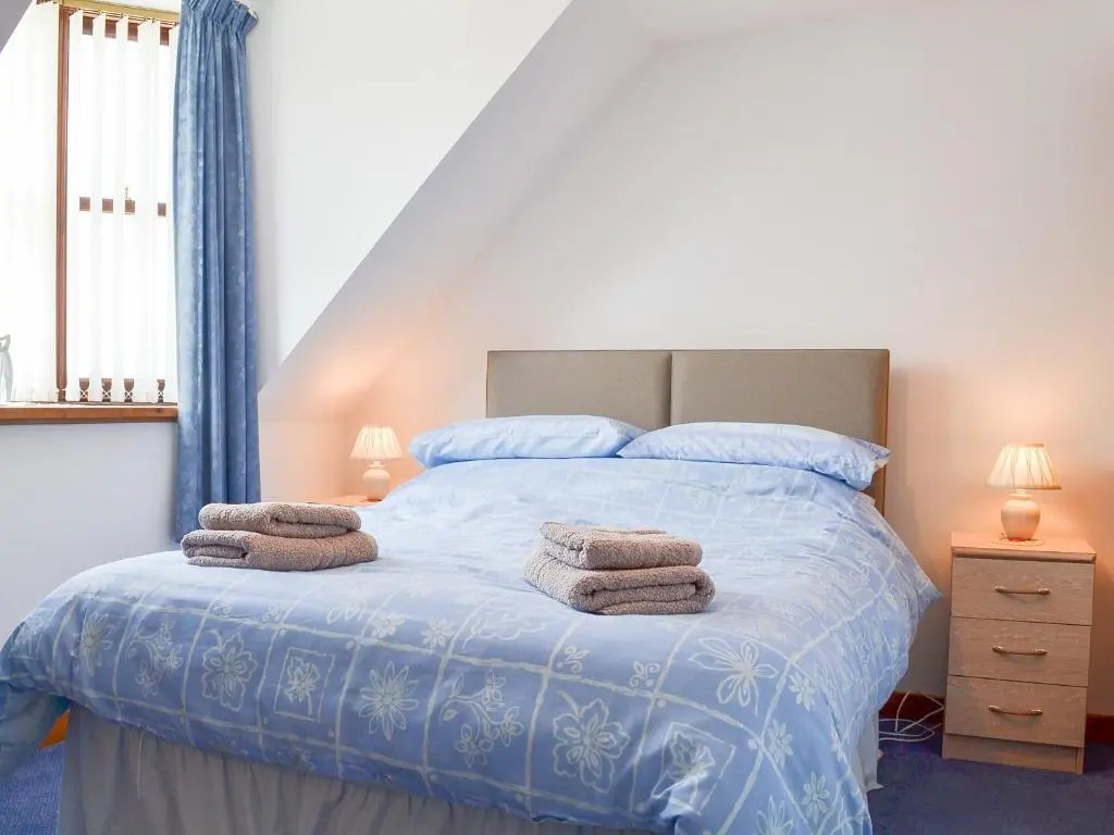 a bedroom with a bed with towels on it at Number 12 in Portknockie