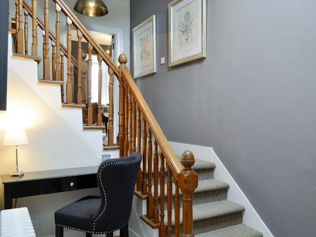 a stairway with a chair and a stair case at Darroch View in Ballater