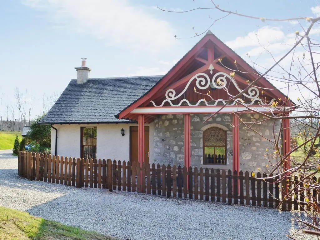 a small house with a fence in front of it at North Lodge Gate House in Urray