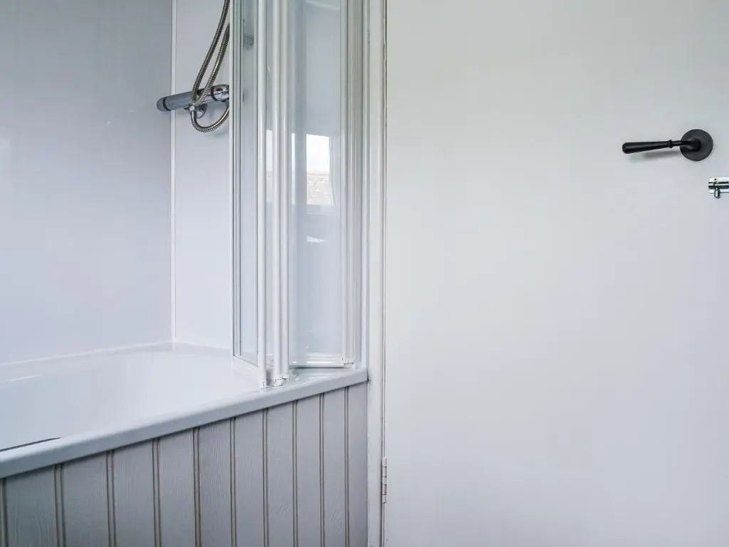 a shower with a window in a bathroom at Needle Cottage in Cullen