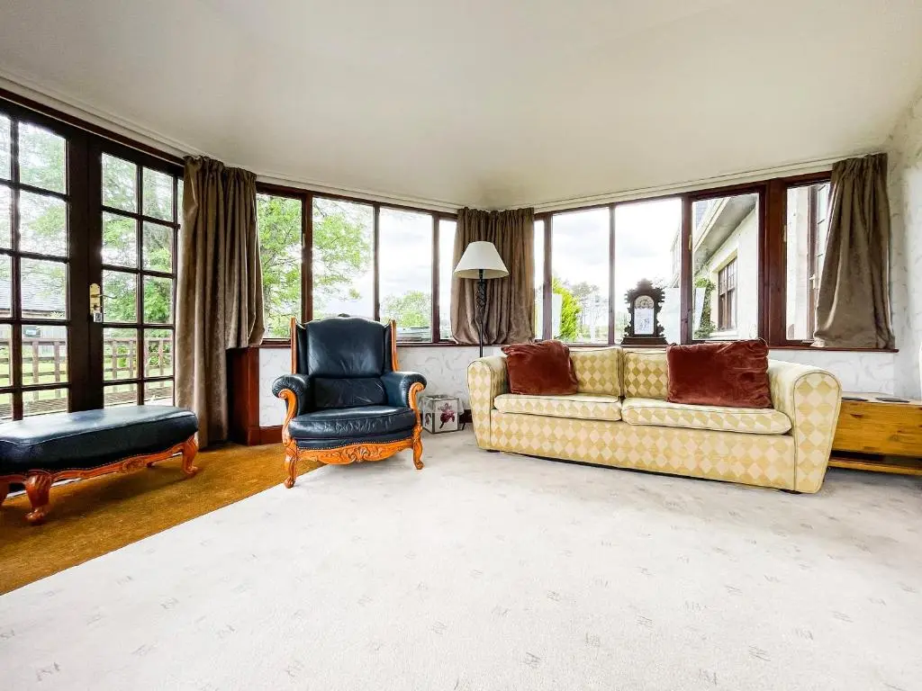 a living room with a couch and a chair and windows at Fourpenny Studio - Uk34745 in Embo