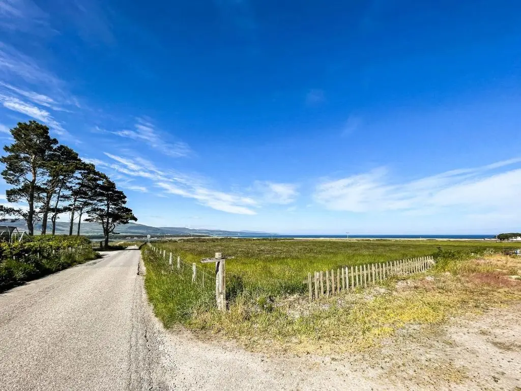 a dirt road with a fence next to a field at Fourpenny Studio - Uk34745 in Embo