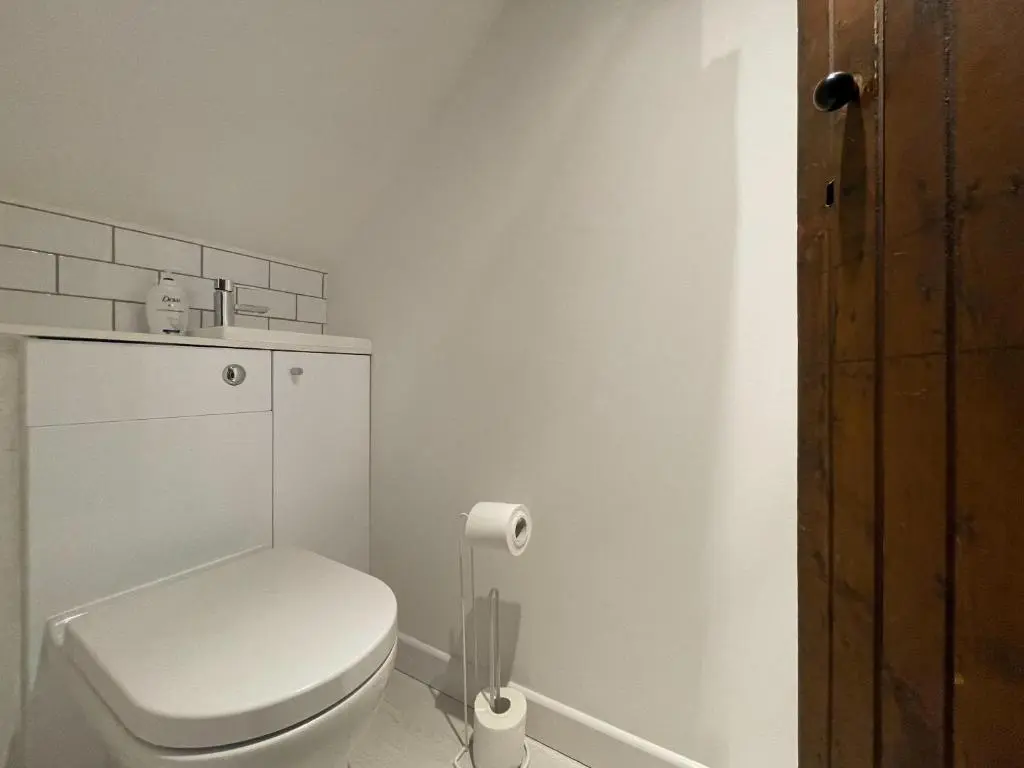 a white bathroom with a toilet and a roll of toilet paper at Stanford House in Inverness