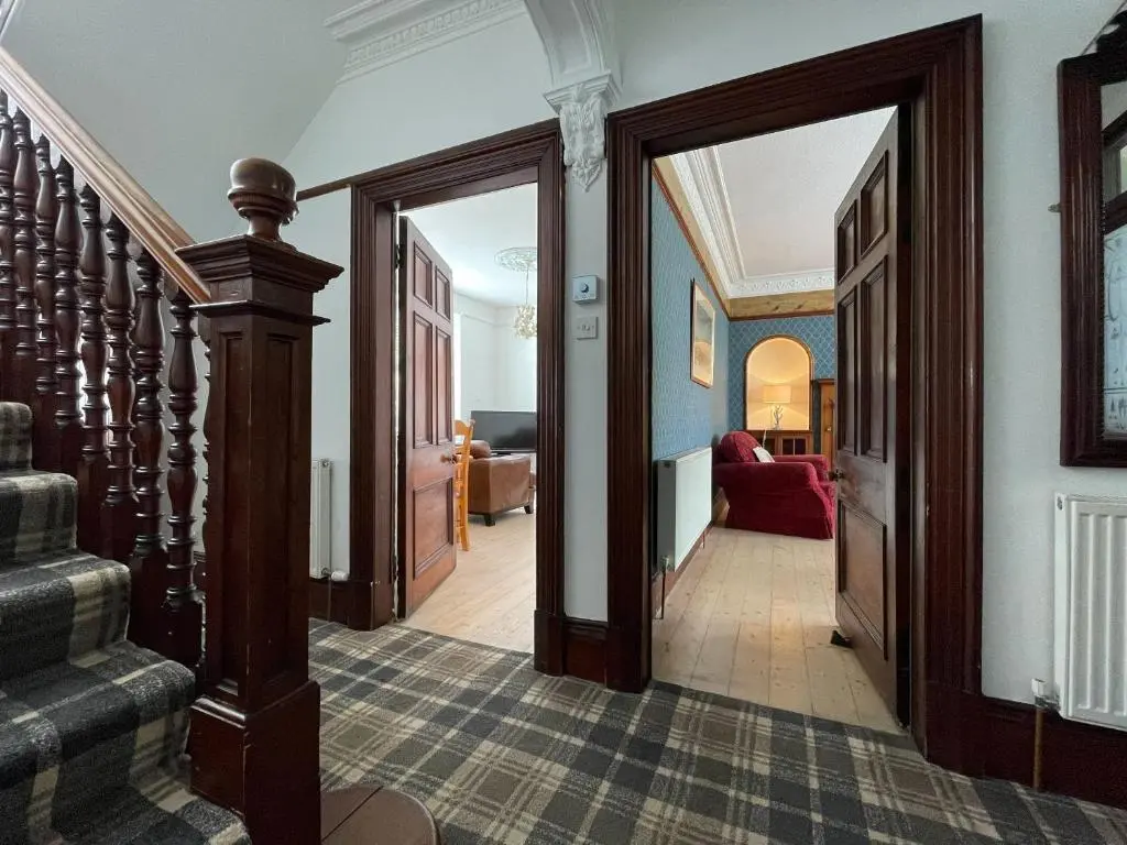 a hallway with doors and stairs in a house at Stanford House in Inverness