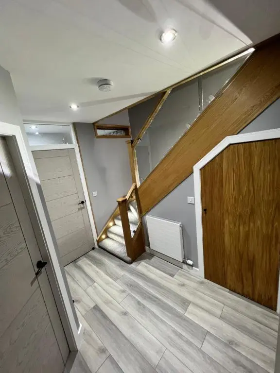 an empty room with a wooden door and a staircase at Town centre 3 bed luxury apartment in Wick