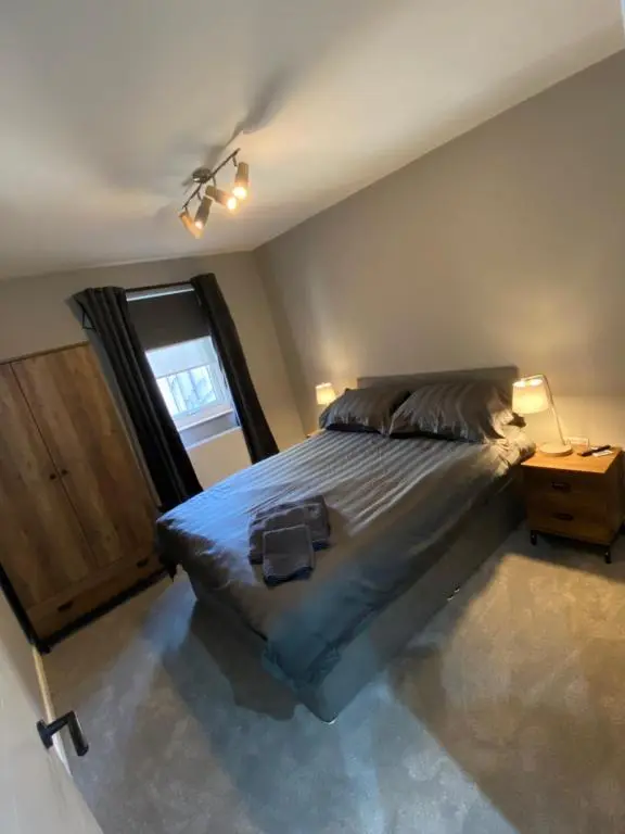 a bedroom with a large bed and a window at Town centre 3 bed luxury apartment in Wick