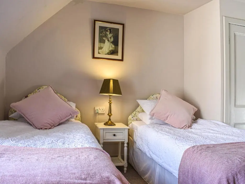 two beds in a room with a lamp on a table at Hayfield - Uk35890 in Turriff