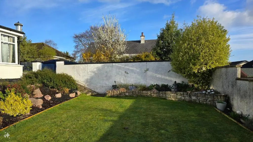 a garden with a retaining wall and a yard at Four Winds Holiday Let in Nairn