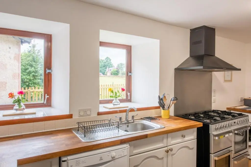 a kitchen with a sink and a stove at Beautiful Character House in Muir of Ord in Muir of Ord