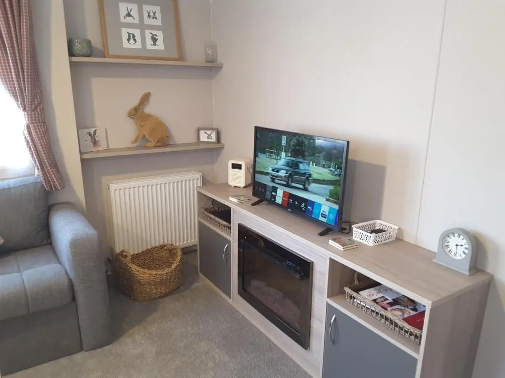 a living room with a flat screen tv on a table at No 46 Coorie-in in Boat of Garten
