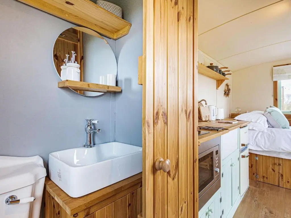 a small kitchen with a sink and a bed at Woodside Hut 3 - Uk36107 in Auchterneed