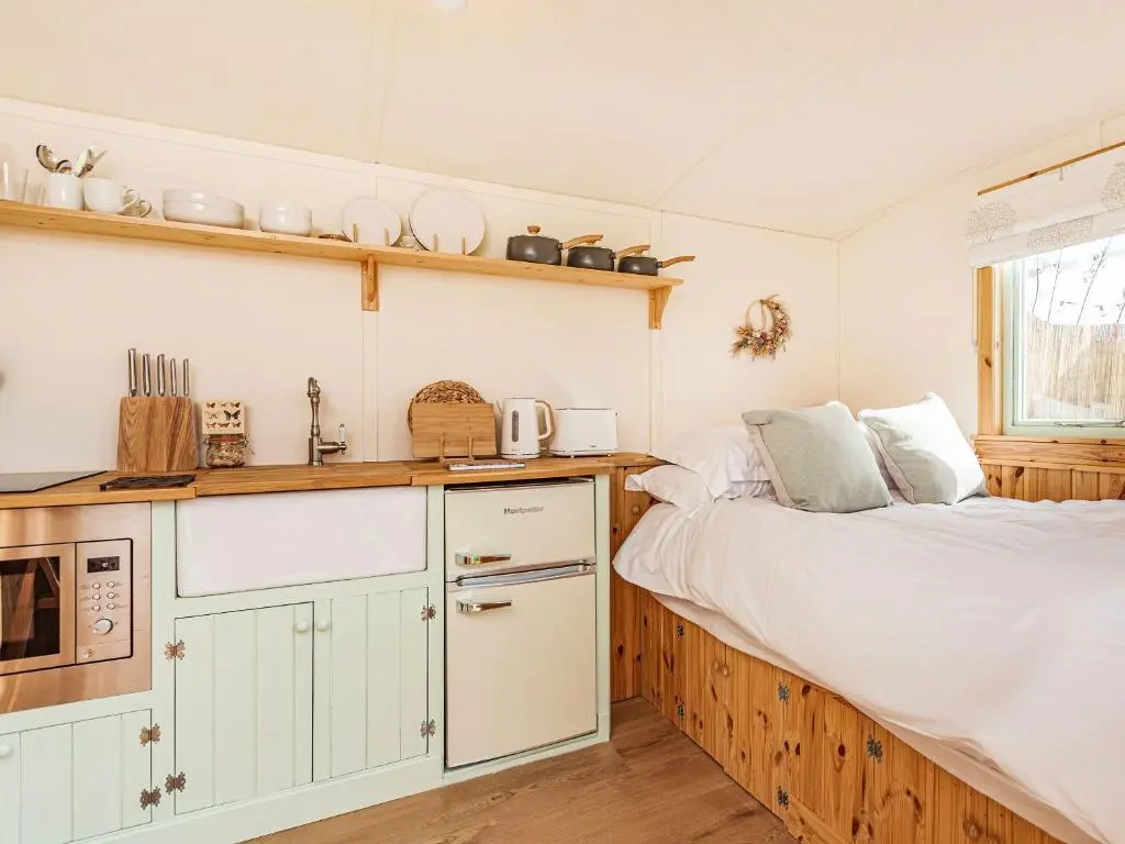 a kitchen with two beds and a sink in a room at Woodside Hut 2 - Uk36106 in Auchterneed