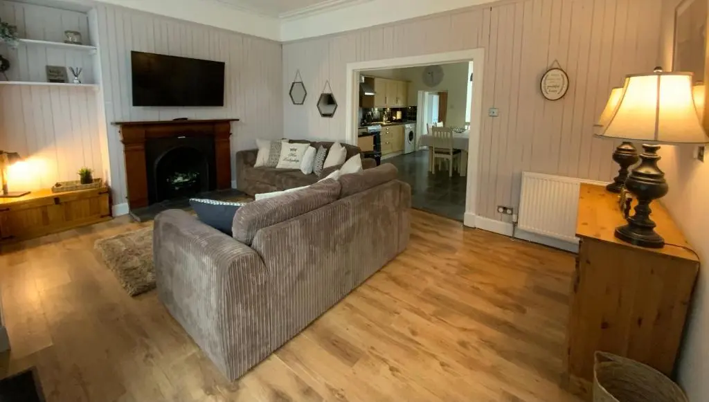 a living room with a couch and a fireplace at Deeside Snugs Apartments in Kincardine O\u02bcNeil
