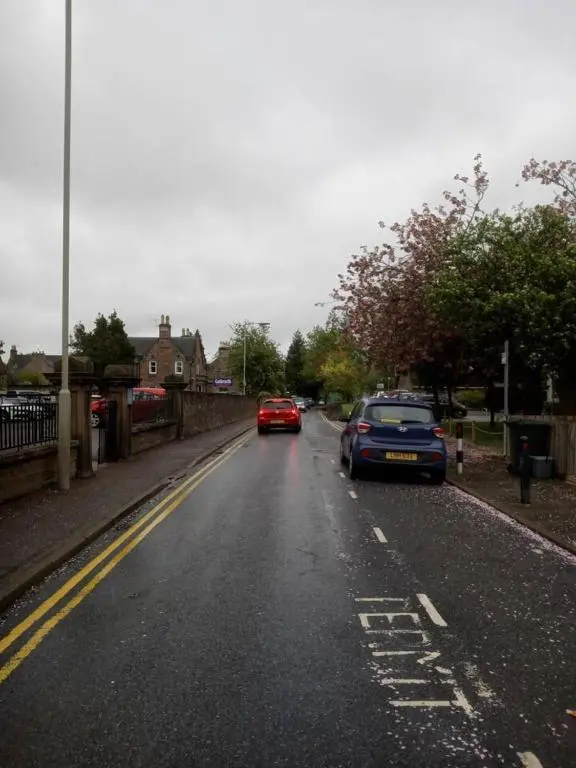 a street with cars driving down a road with trees at 3-Bed House Sleeps 5 5 min walk from City Centre in Inverness