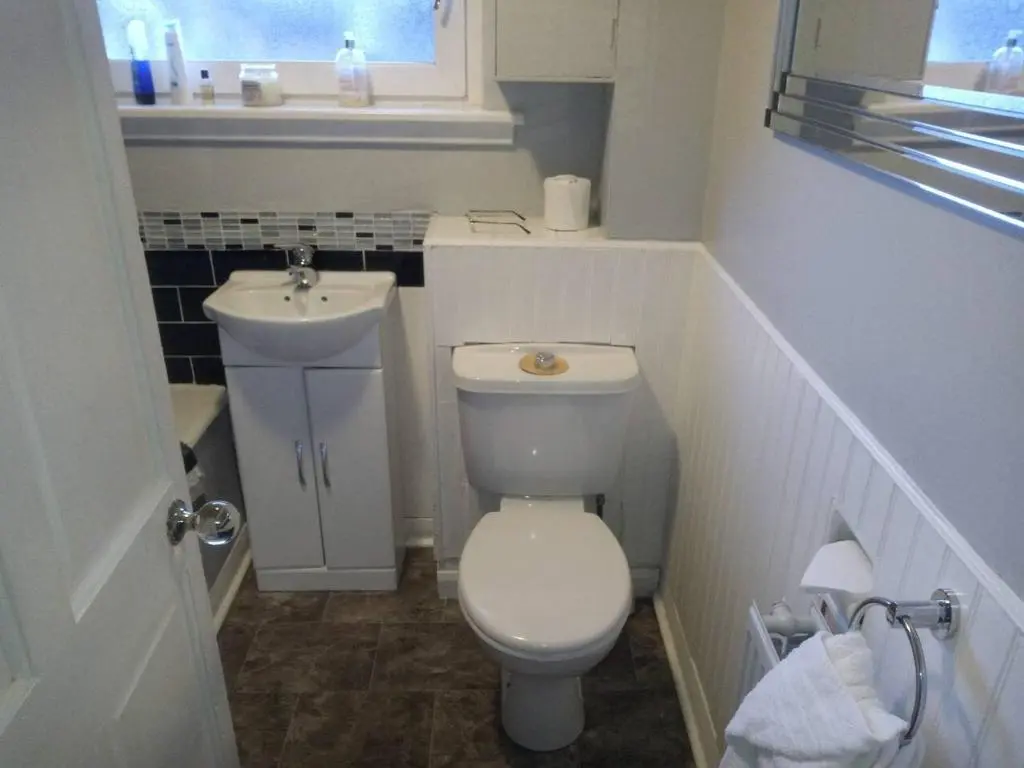 a small bathroom with a toilet and a sink at 3-Bed House Sleeps 5 5 min walk from City Centre in Inverness