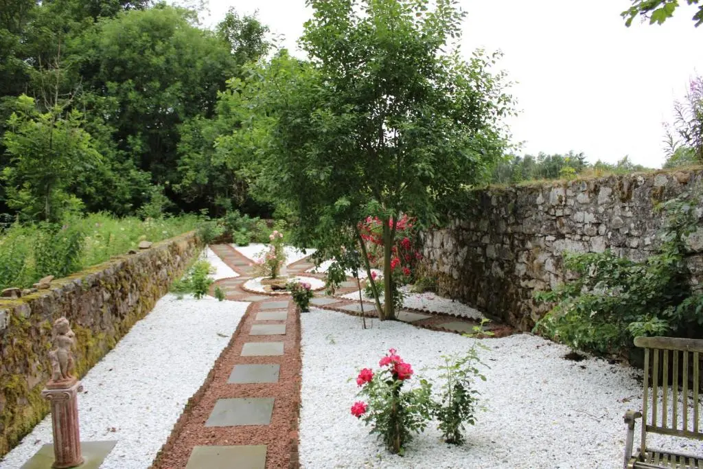 a garden with a stone wall and some flowers at Lickleyhead Castle in Insch