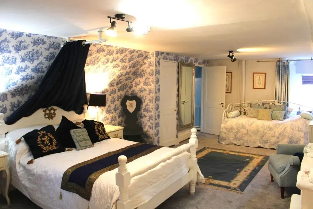 a bedroom with two beds with blue and white wallpaper at Lickleyhead Castle in Insch