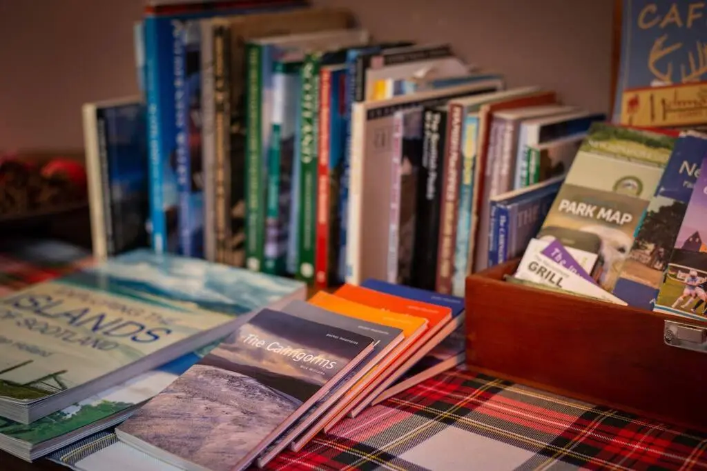 a pile of books sitting on top of a table at The Beeches Studio, Highlands of Scotland in Newtonmore