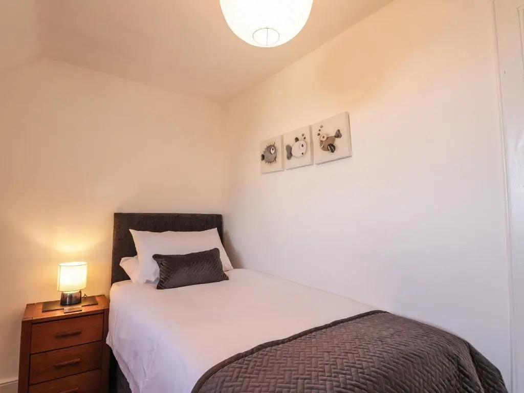 a bedroom with a bed and a night stand with a lamp at 62 Society Street in Nairn