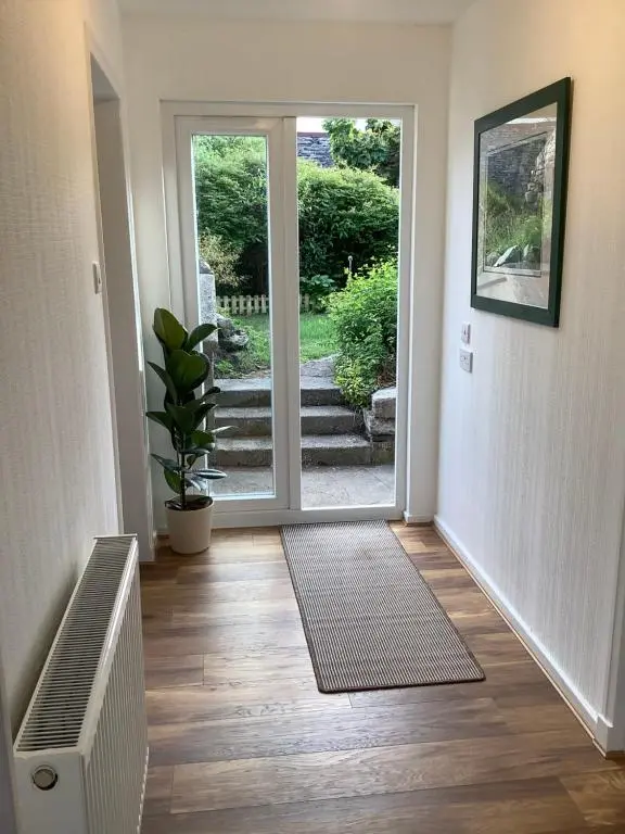 a hallway with an open door with a potted plant at Harbour View in Wick