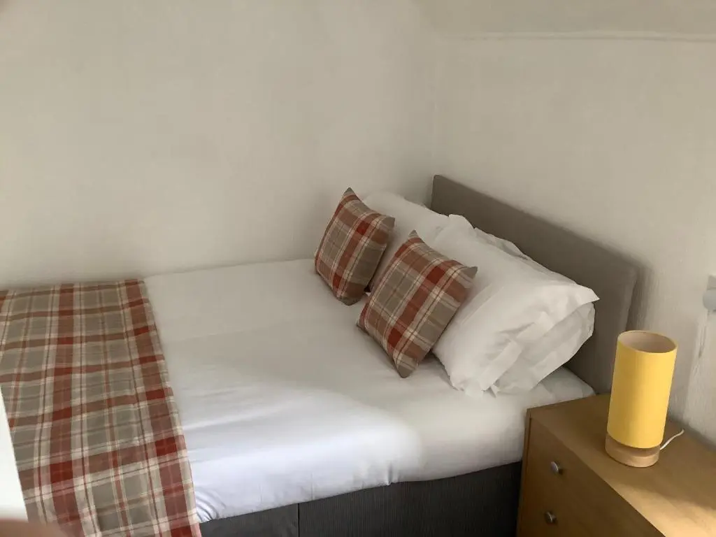a bed with two pillows and a blanket on it at Harbour View in Wick