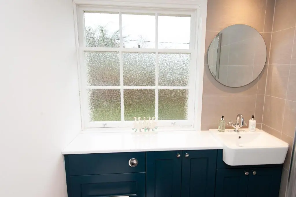 a bathroom with a sink and a window at Parkside, The Loch Ness Cottage Collection in Inverness