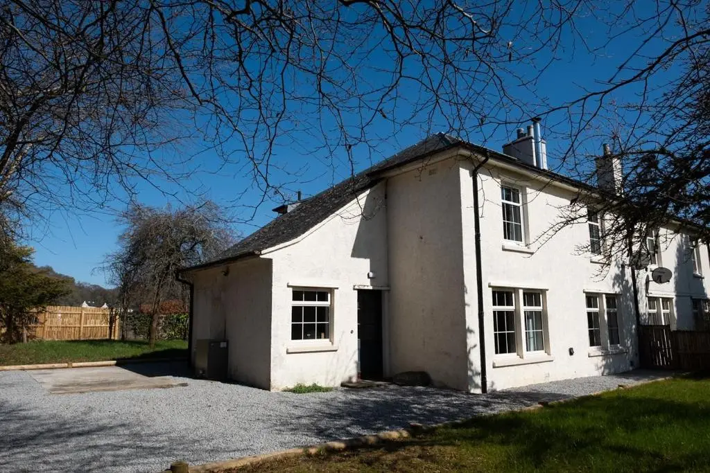 an old white house with a driveway at Parkside, The Loch Ness Cottage Collection in Inverness