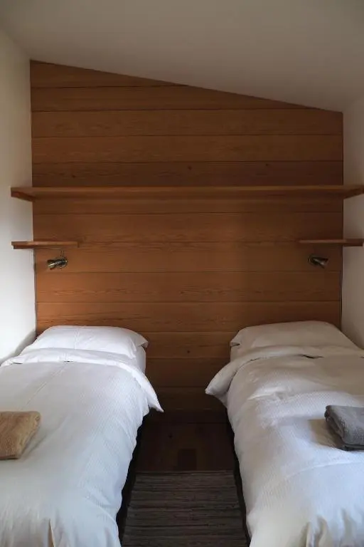 two beds in a room with white pillows at Marcassie Farm Lodges - Ash Studio in Forres