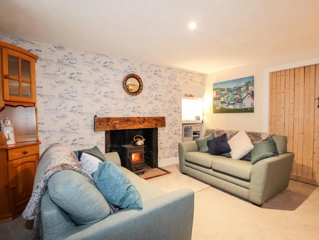 a living room with a couch and a fireplace at Griffin Cottage in Nairn