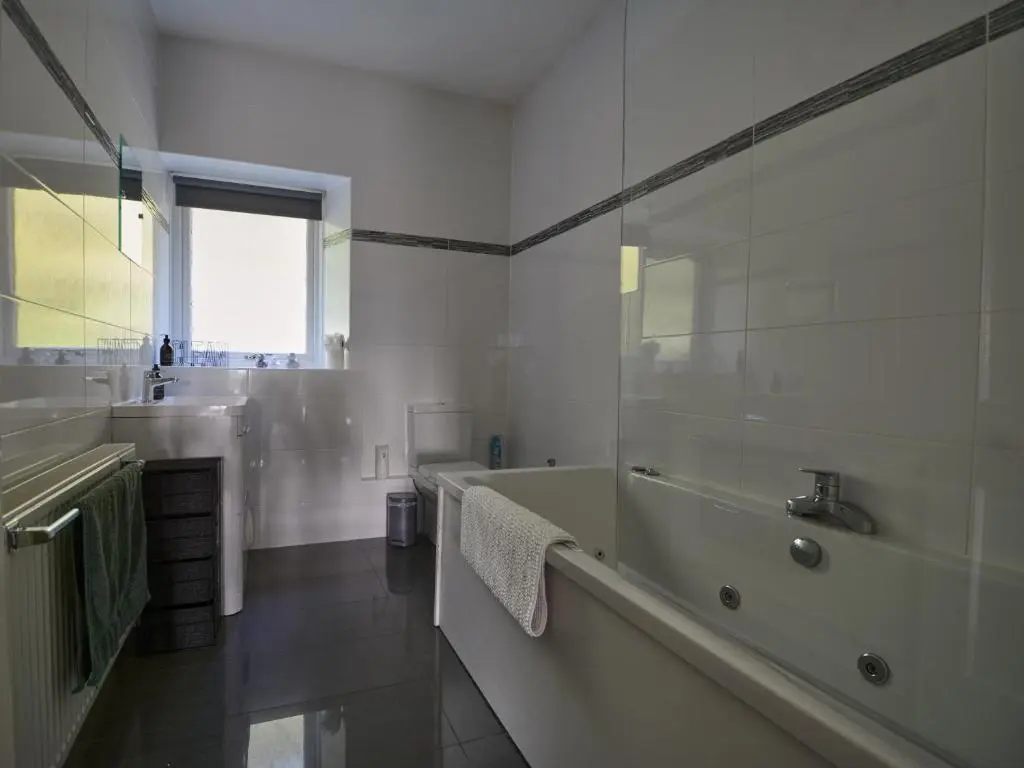 a white bathroom with a tub and a sink at Wester Curr Cottage - Luxury 5-Star Cottage with Private Pool & Hot Tub in Grantown on Spey