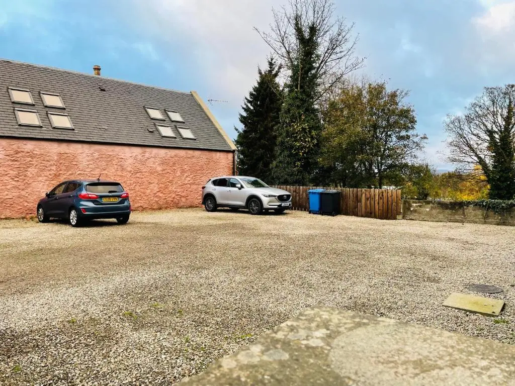 two cars parked in front of a brick house at Shandwick House in Tain