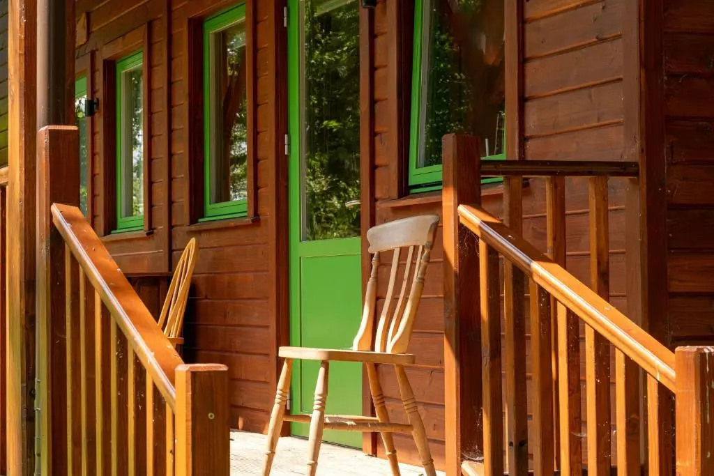 two chairs sitting on the porch of a cabin at Marcassie Farm Lodges - Blackthorn Studio in Forres