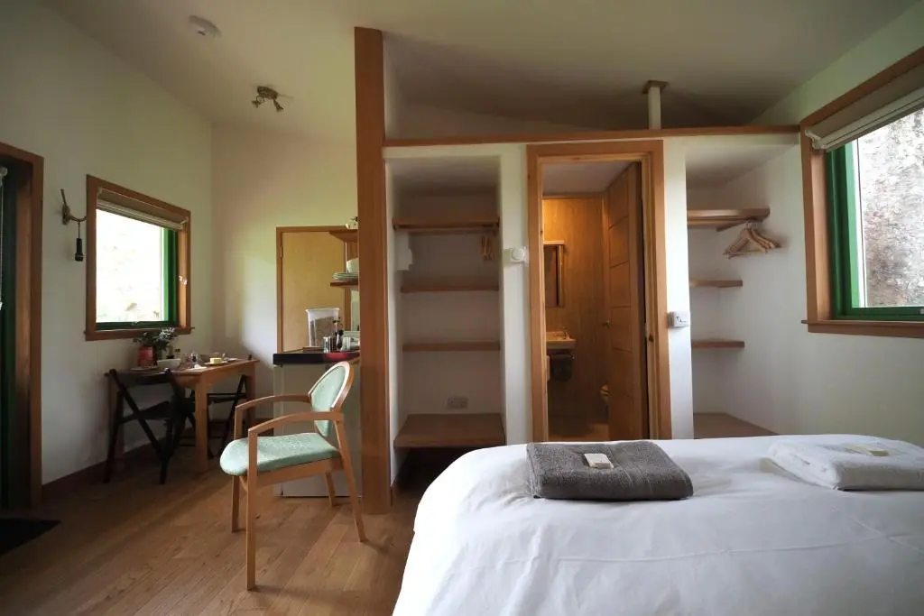 a bedroom with a bed and a desk and a chair at Marcassie Farm Lodges - Blackthorn Studio in Forres