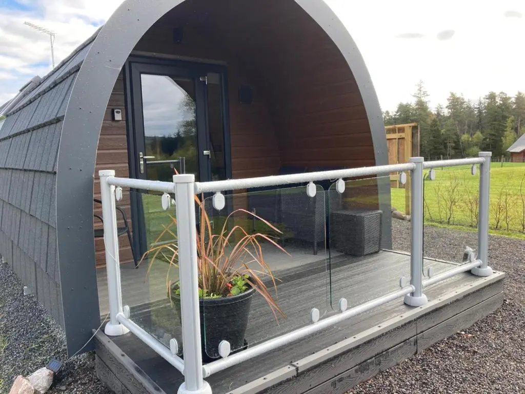 a dome house with a deck with a potted plant at Owls Retreat Glamping Pod with Hot tub in Keith
