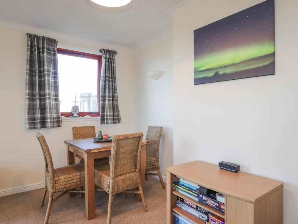 a dining room with a table and chairs at Aurora View in Forres
