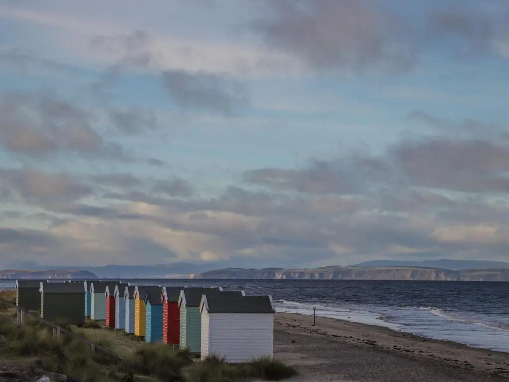 a row of colorful beach huts on the beach at Aurora View in Forres