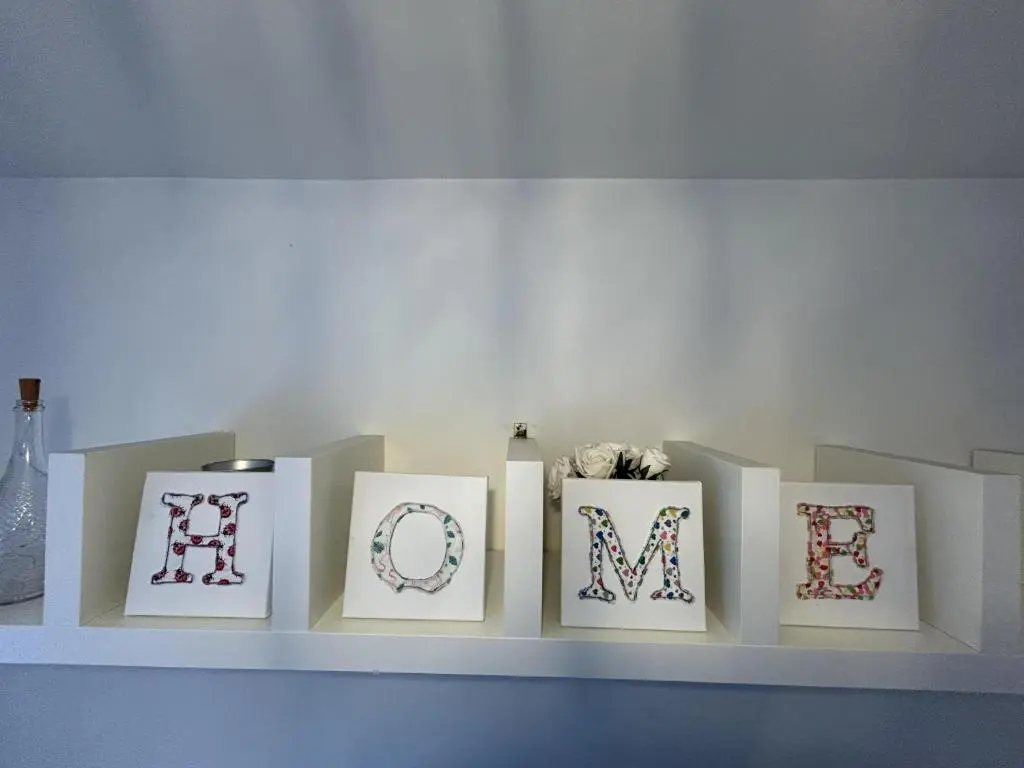 a shelf with four framed pictures on it at Dunedin House -Contractors - Business Travellers in Huntly