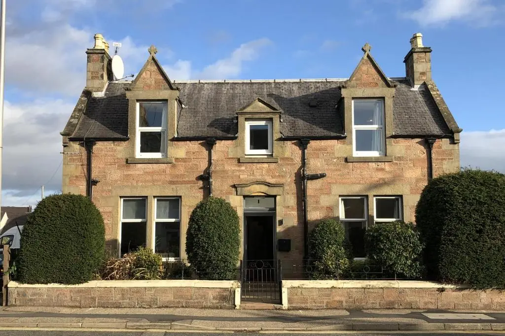 an old brick house with a black roof at Winmar in Inverness