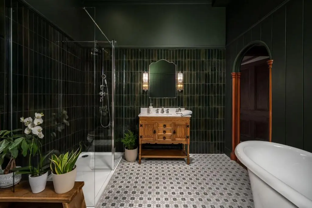 a green bathroom with a sink and a bath tub at The Old Bank House Self Catering Apartment Dornoch in Dornoch