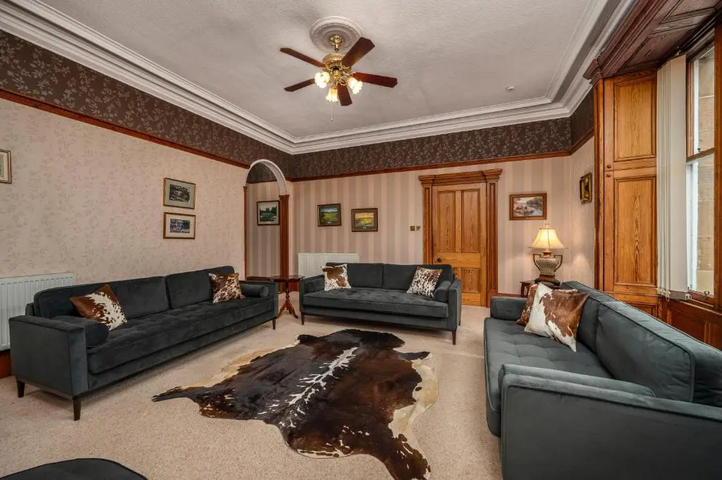 a living room with two couches and a table at The Old Bank House Self Catering Apartment Dornoch in Dornoch