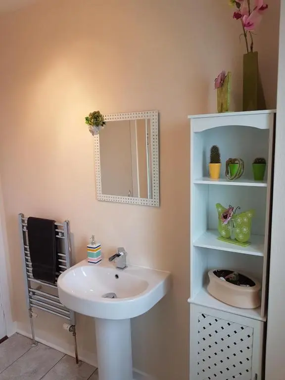 a bathroom with a sink and a mirror at Spacious 2 double bedrooms house for a relaxing stay. in Inverness