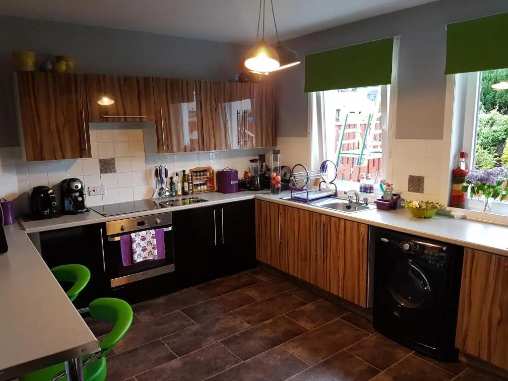 a kitchen with wooden cabinets and a black dishwasher at Spacious 2 double bedrooms house for a relaxing stay. in Inverness