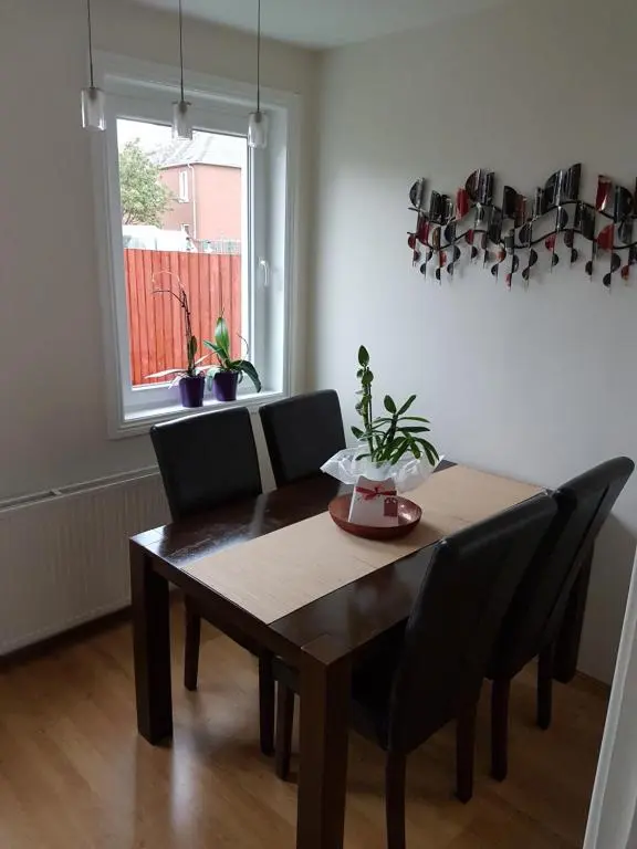 a dining room table with black chairs and a window at Spacious 2 double bedrooms house for a relaxing stay. in Inverness